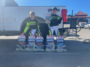 Dash and Maddox posing with their racing certificates that say 1st place