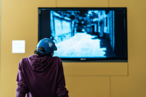artist viewing a tv screen of a vintage film in black and white
