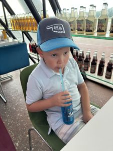 A little boy drinking a glass bottle soda through a straw at Pops. This is a great fun idea to beat the summer heat for little kids.