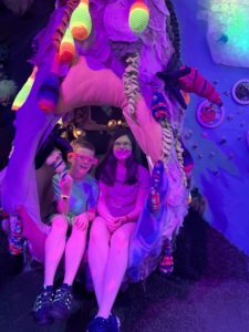 Two children sitting in a chair surrounded in fabric enjoying interactive family fun at Factory Obscura
