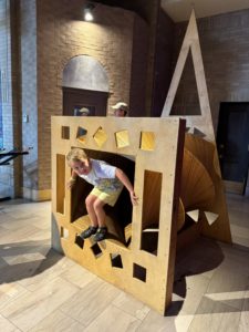 A young boy is playing in an interactive, climbing exhibit of Science City in Kansas City 