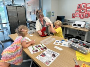 Two kids using a button maker in the Makerspace at the Metropolitan Library System. 
