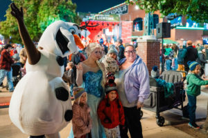 Family poses with Olaf and Elsa at the Oklahoma City Tree Lighting Festival presented by Heartland. 
