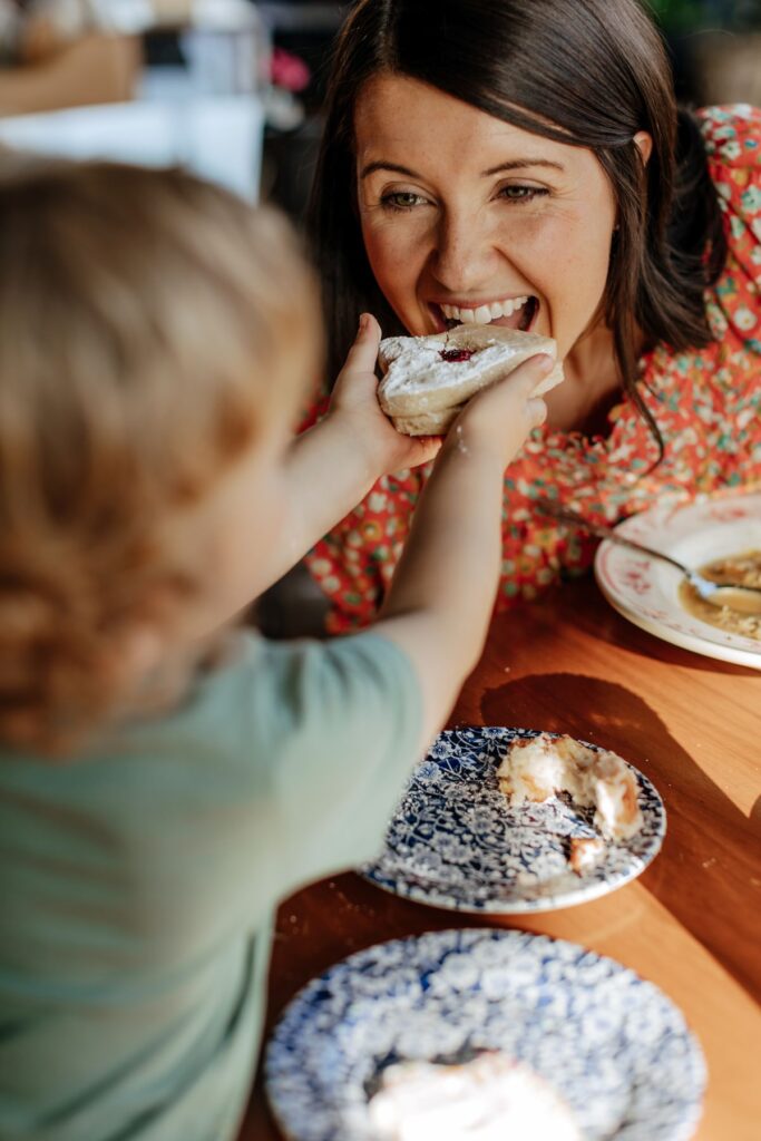 Mom and child snack on cookies at Harvey Bakery. 